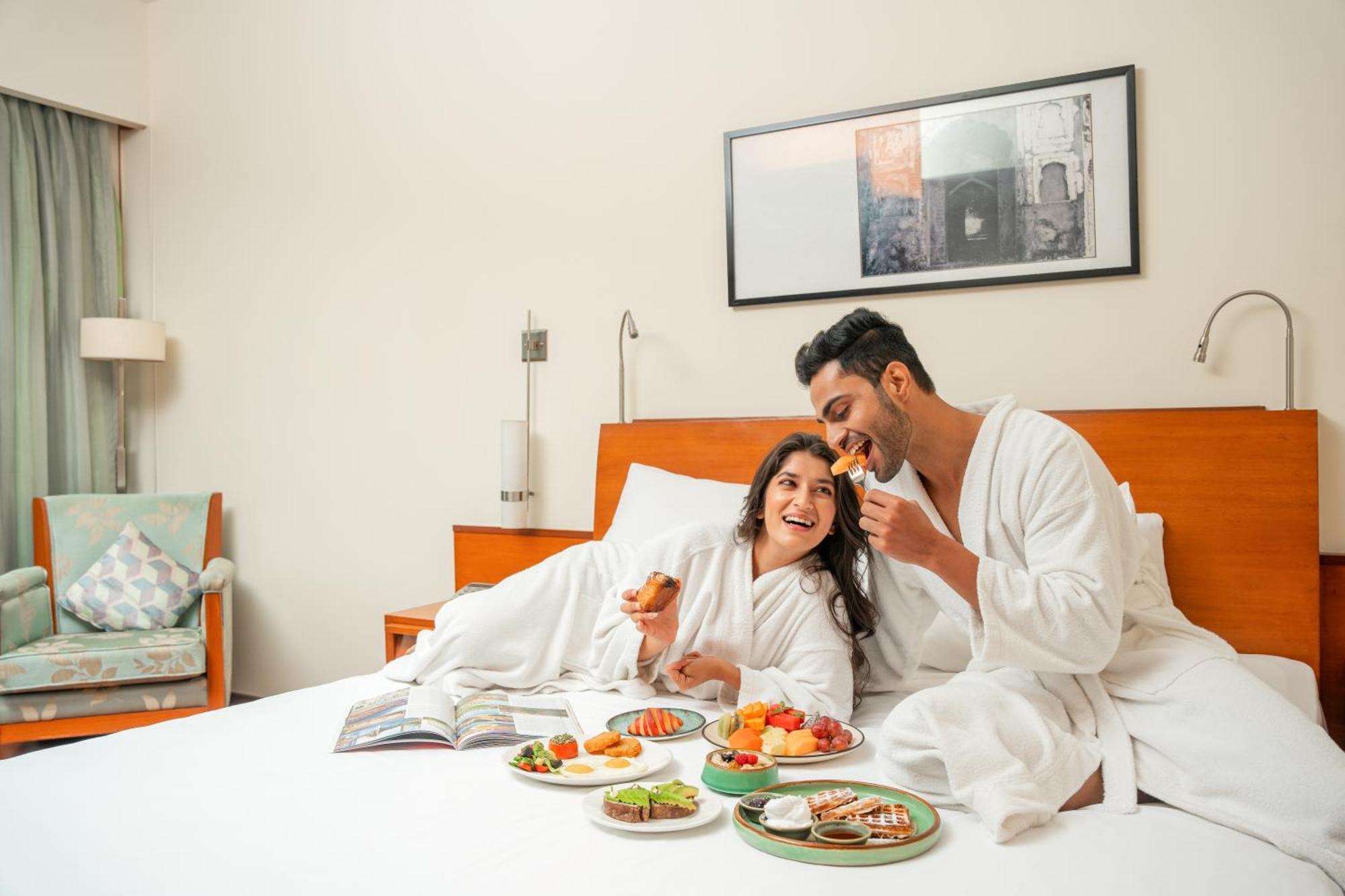하얏트 푸네 호텔 외부 사진 A couple eating breakfast in bed